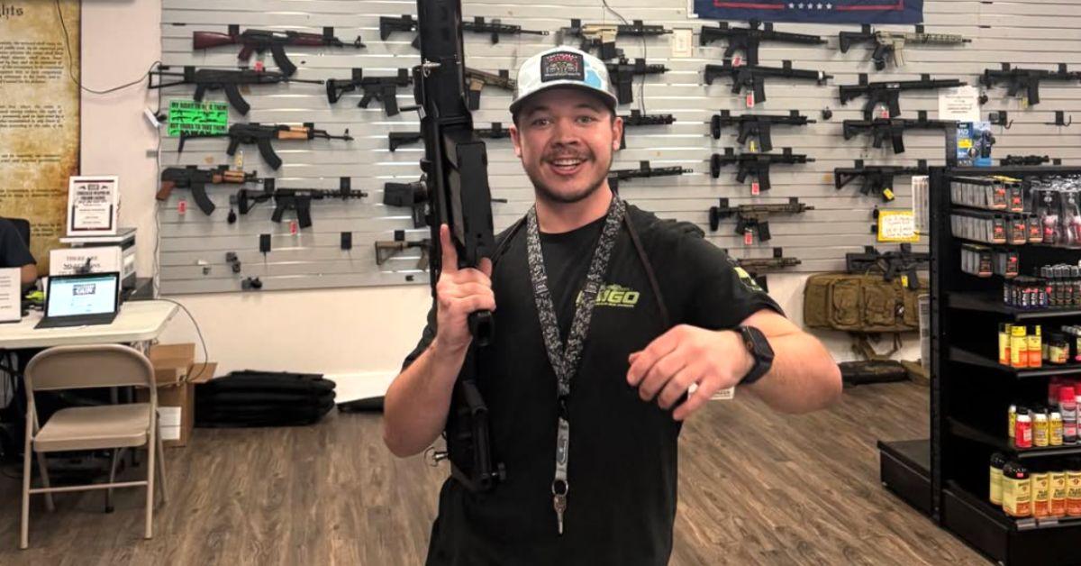 Kyle Rittenhouse holding a gun in a gun store.