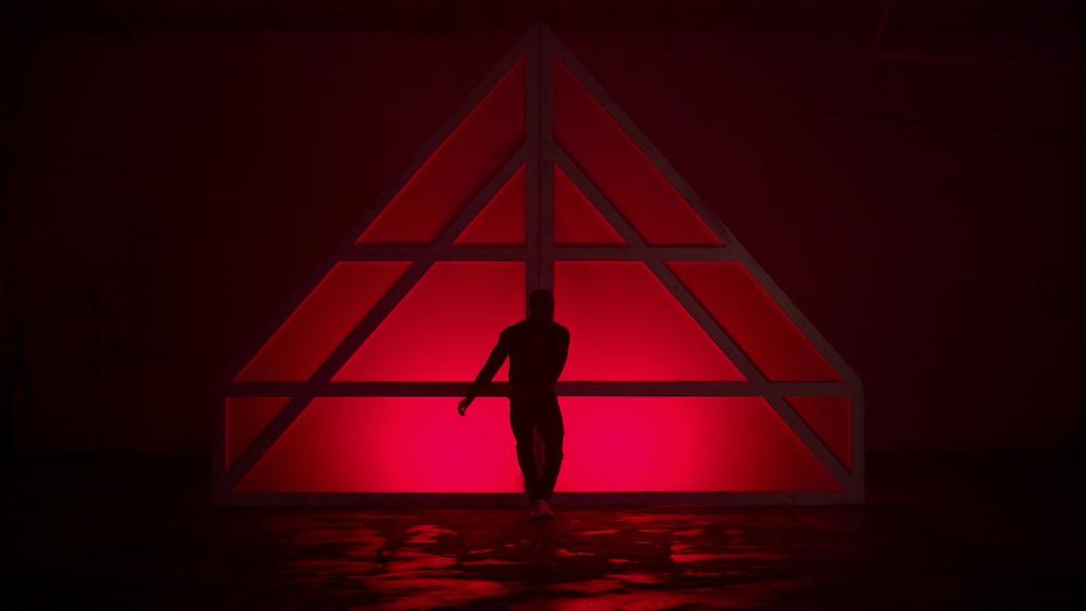 A dancer in front of red lights