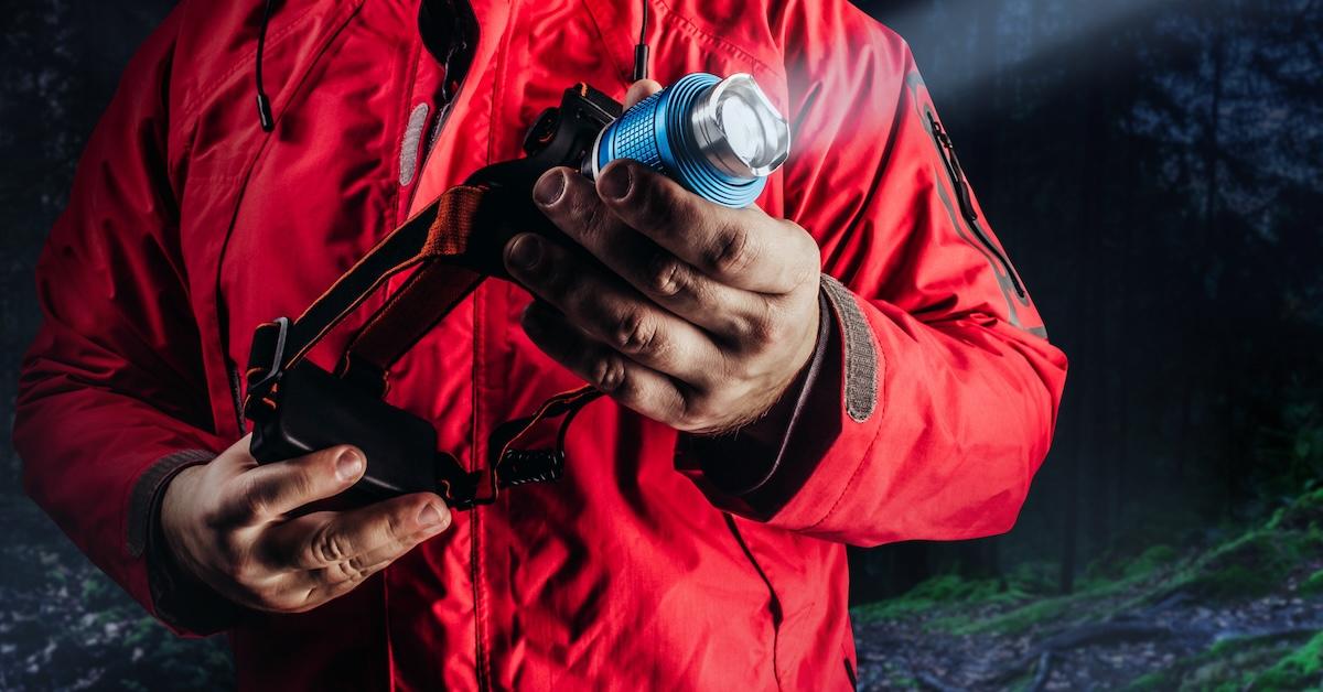 A person holding headlamp/outdoor flashlight