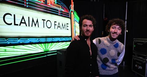kevin and frankie jonas in front of sign reading claim to fame
