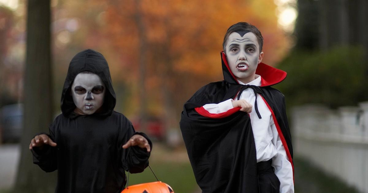 Kids trick or treating on Halloween as a scary guy and vampire