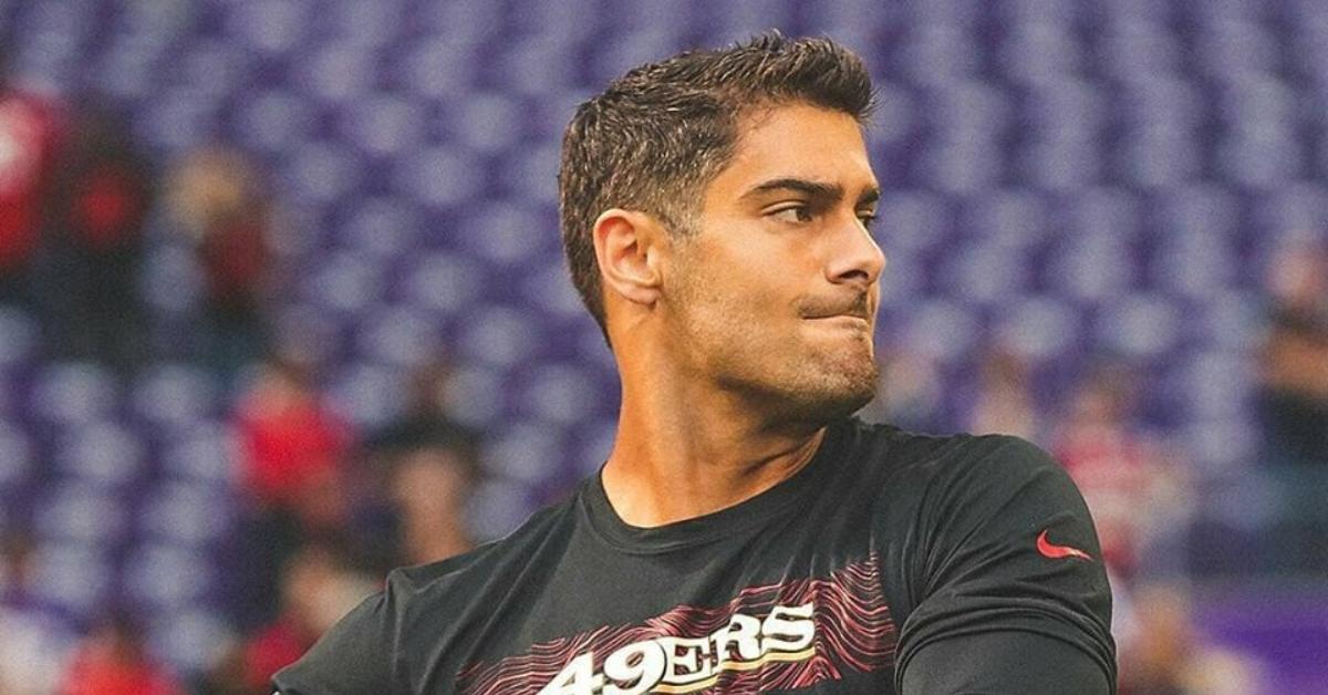 Jimmy Garoppolo throws a football wearing a raider's jersey.