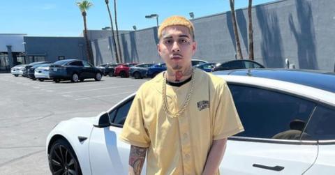 MoneySign Suede standing in front of a white car wearing a tan jersey