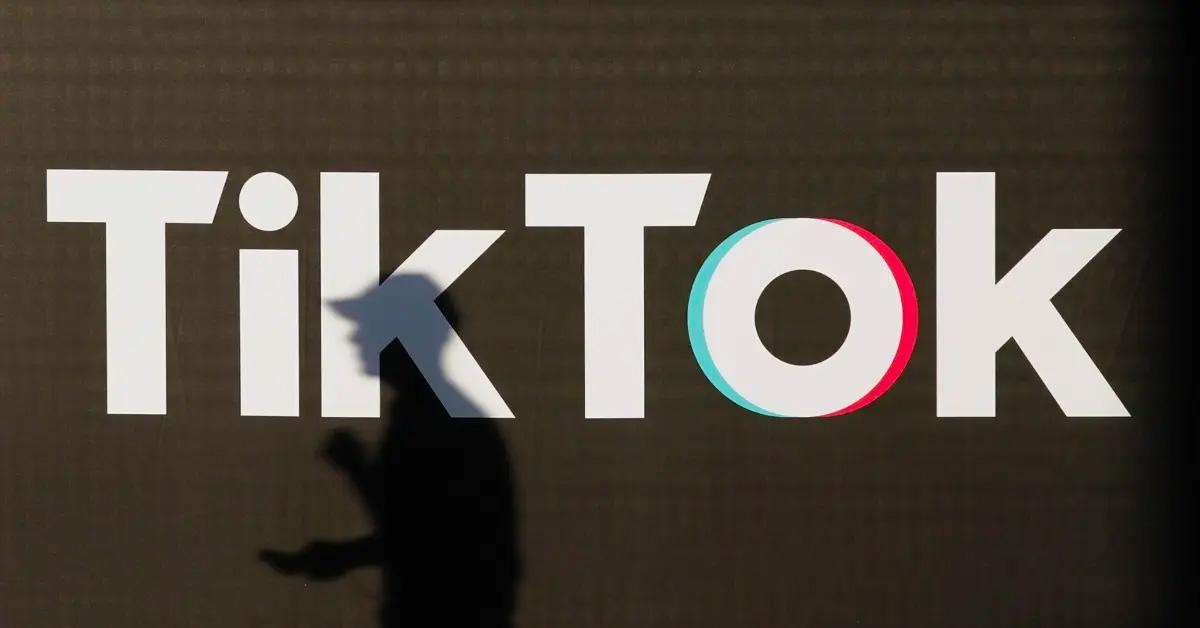 TikTok logo with a man's shadow in front of it. 