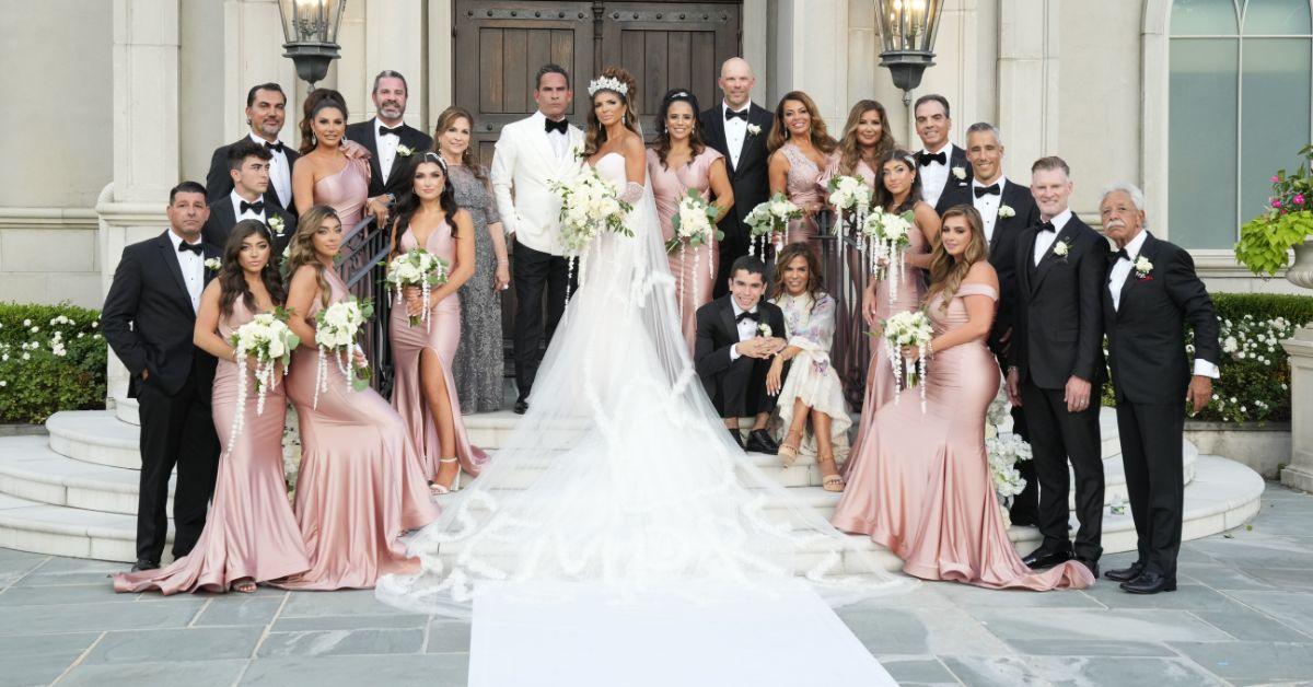 Teresa Giudice and Louie Ruelas posing with their bridal party in wedding attire.