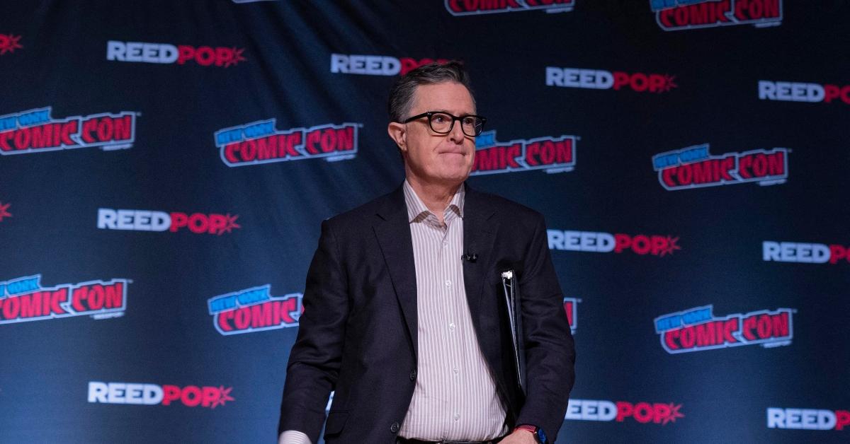 Stephen Colbert poses at Comic Con in a striped button-up shirt