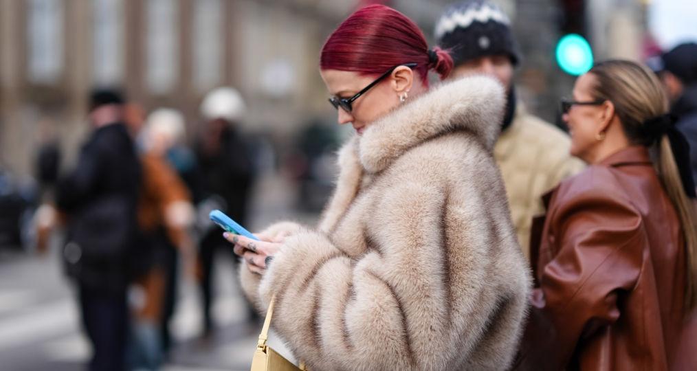 A woman looking down at her phone and texting