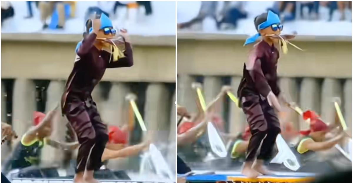 An Indonesian kid on a rowing boat dancing.