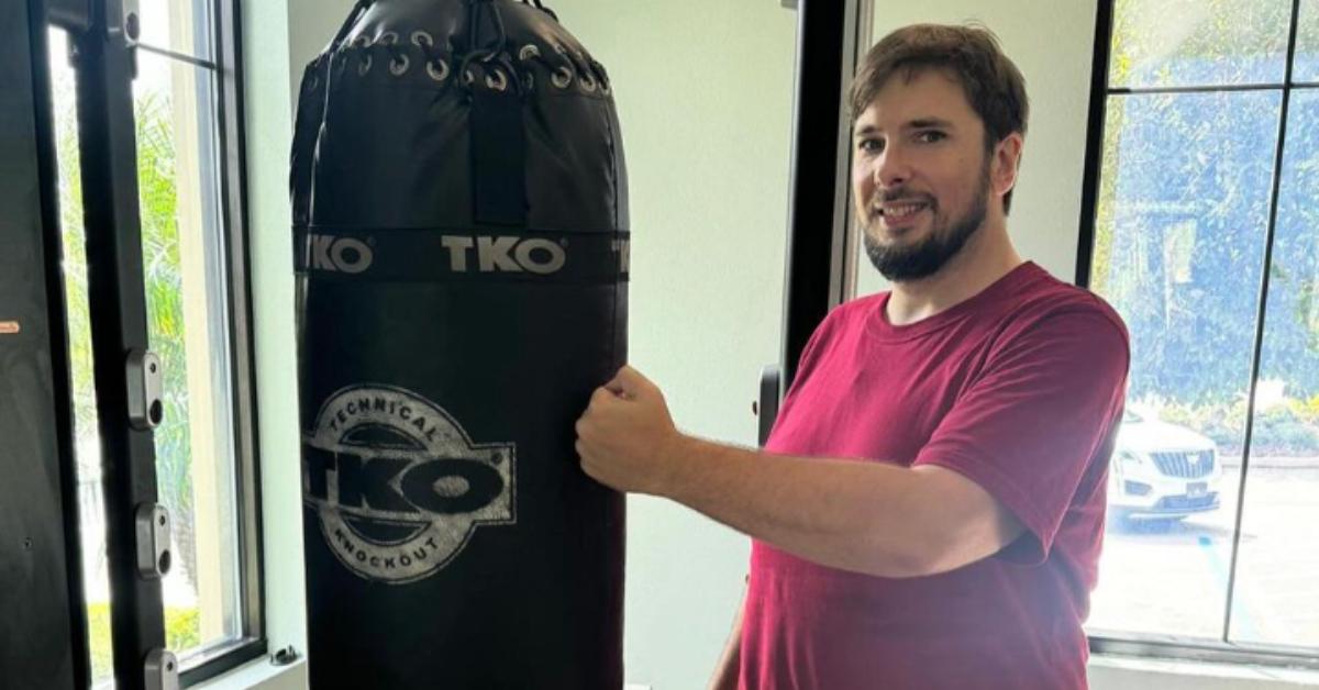 '90 Day Fiancé' star Colt Johnson smiles and poses next to a punching bag.