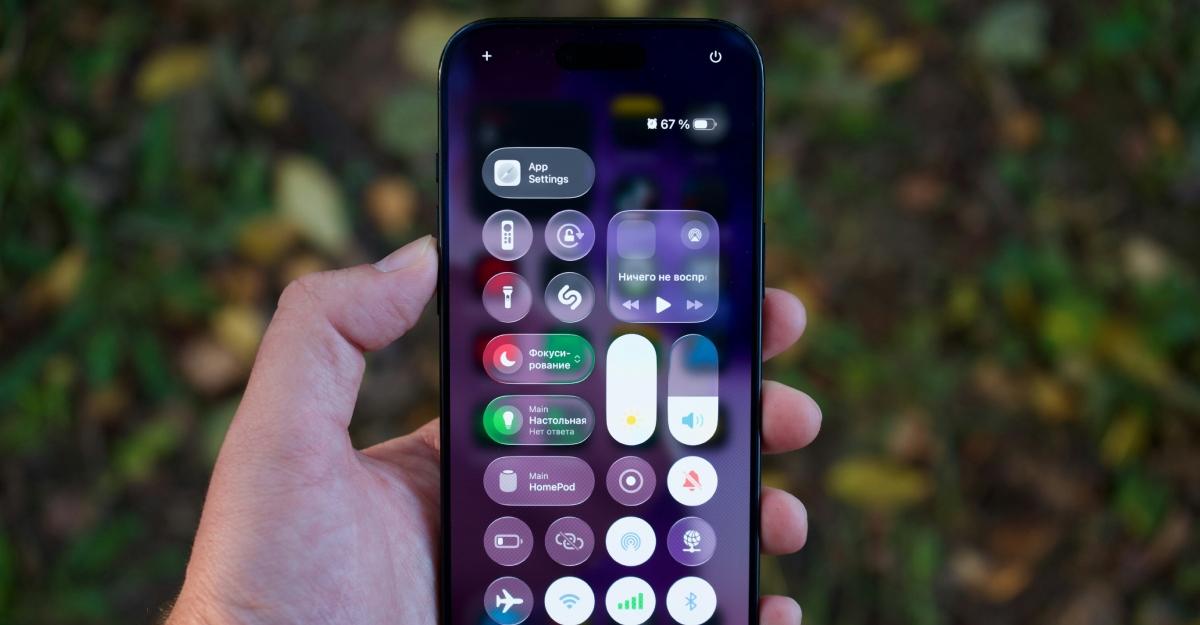 A hand holds an iPhone in front of dark foliage. The phone shows lock screen widgets.