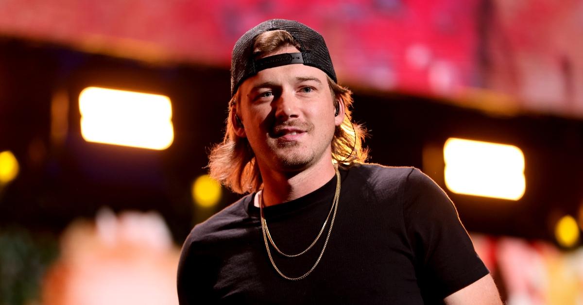 Morgan Wallen with a slight smile on stage.