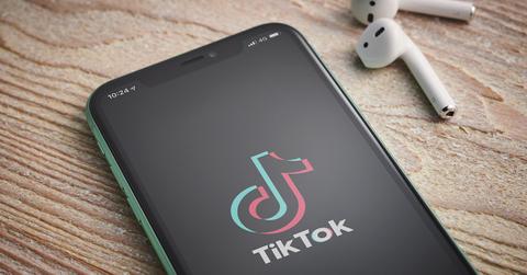 TikTok logo on a phone screen with headphones.