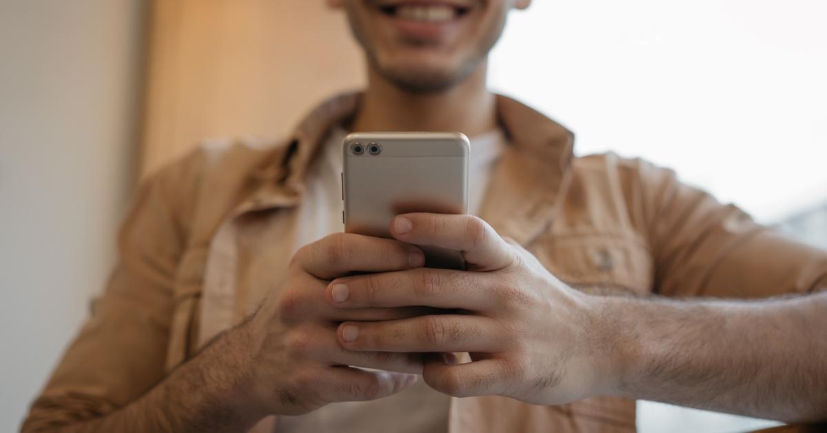 Smiling guy using his smart phone.