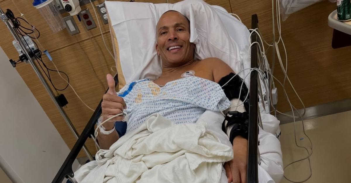 Mike Woods gives a thumbs up from the hospital bed.