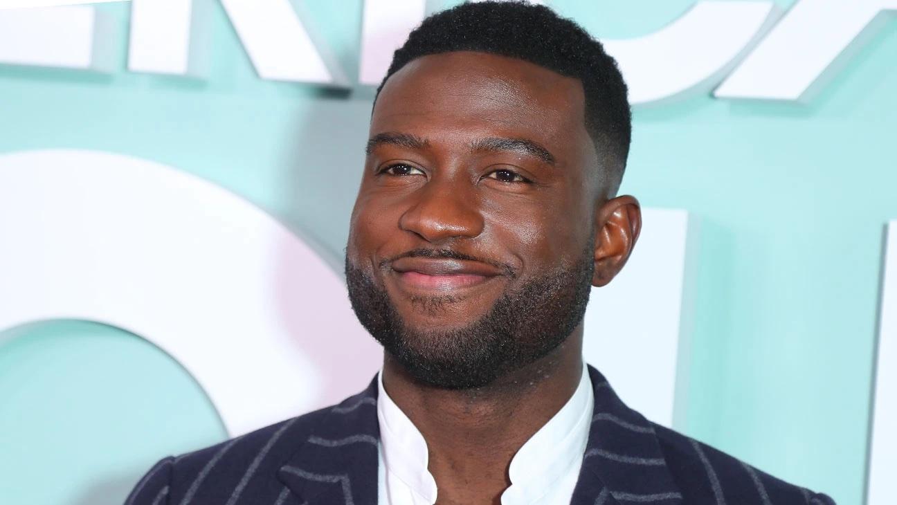 Still shot of Sinqua smiling on a red carpet.