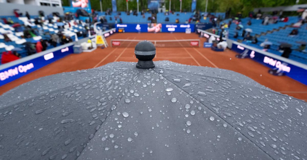 A wet umbrella at a tennis game suspended by the weather