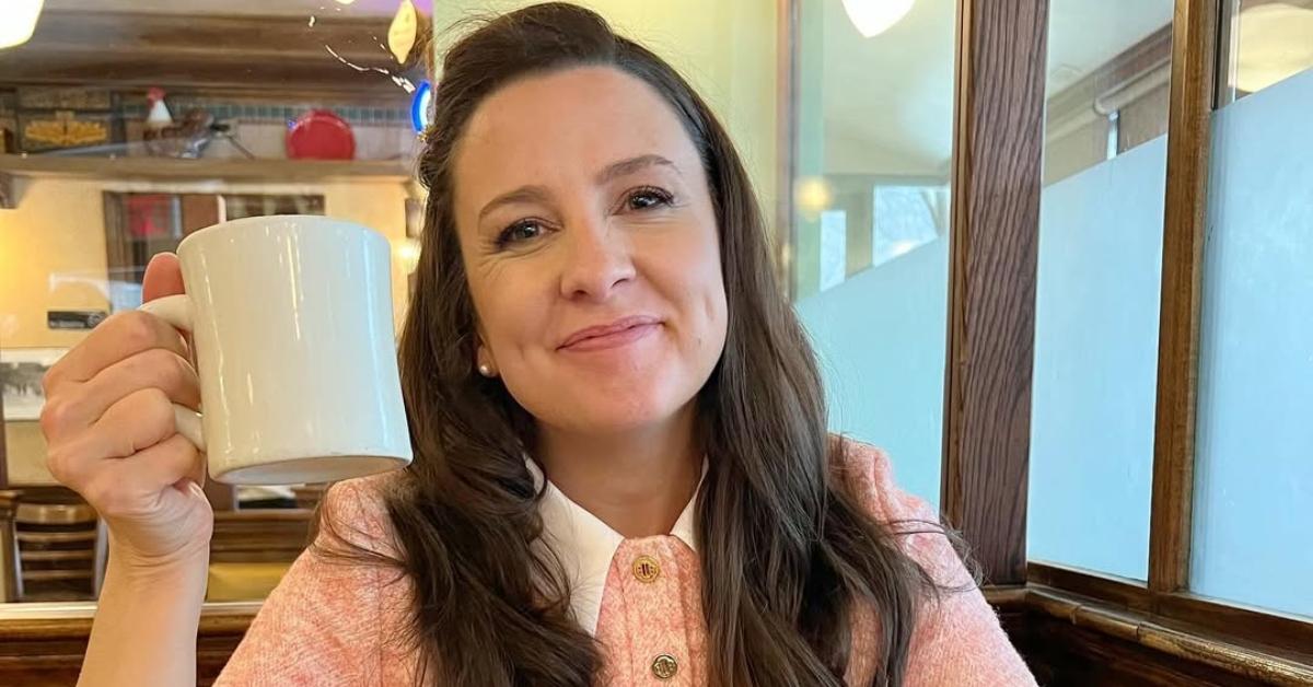 Ms Rachel with a cup of coffee in a restaurant.