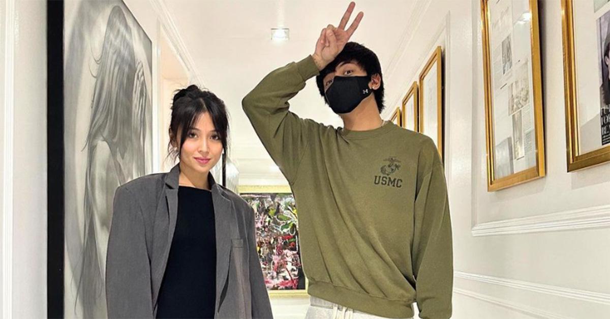 Kathryn Bernardo and Daniel Padilla standing in a hallway with picture frames on the wall. 