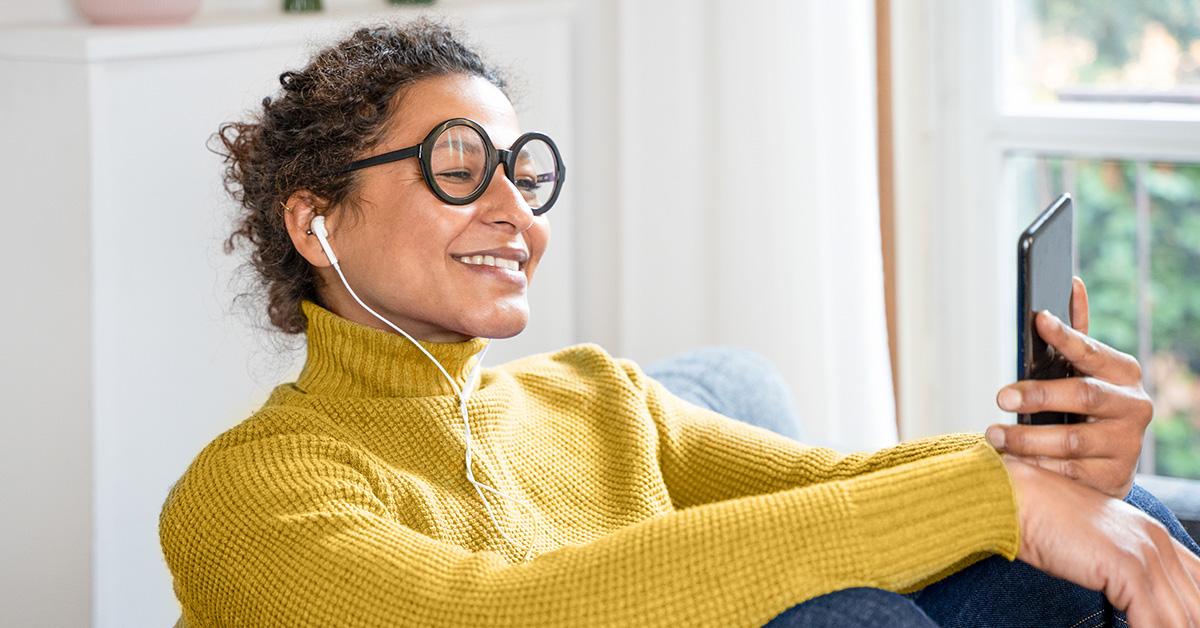 Woman looking at phone while listening to music. 