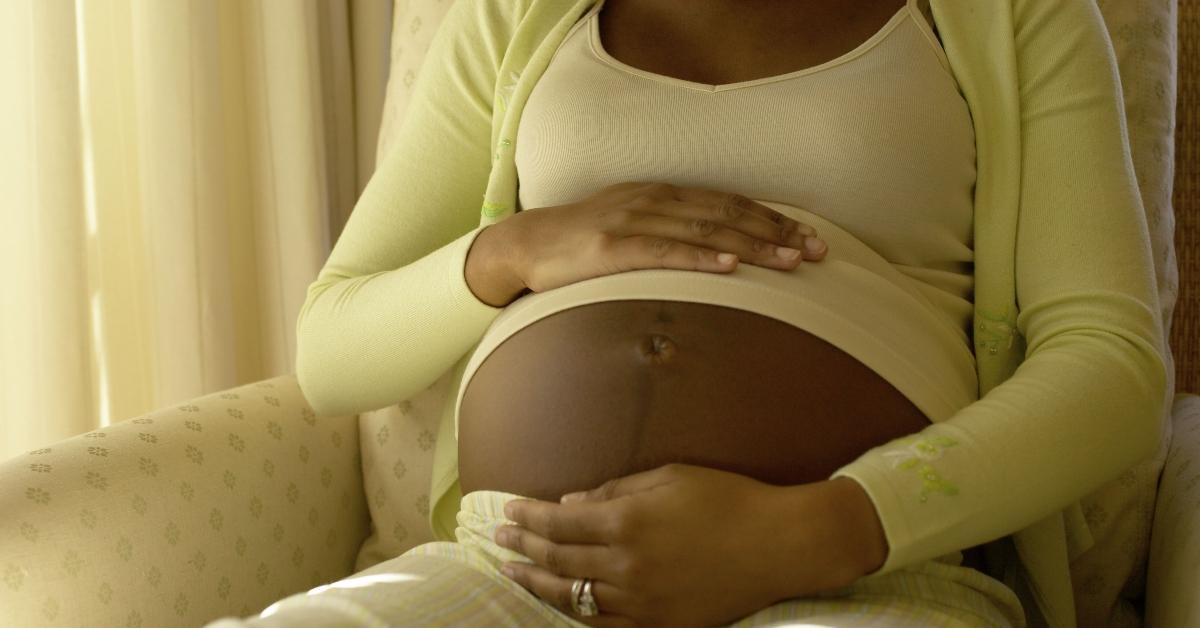 Black woman cradling baby belly