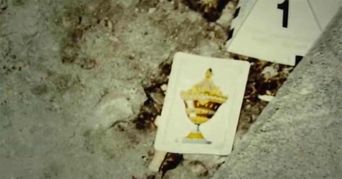 A crime scene with a playing card on the ground