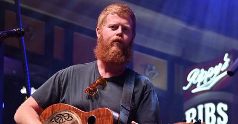 Oliver Anthony performing with a guitar.