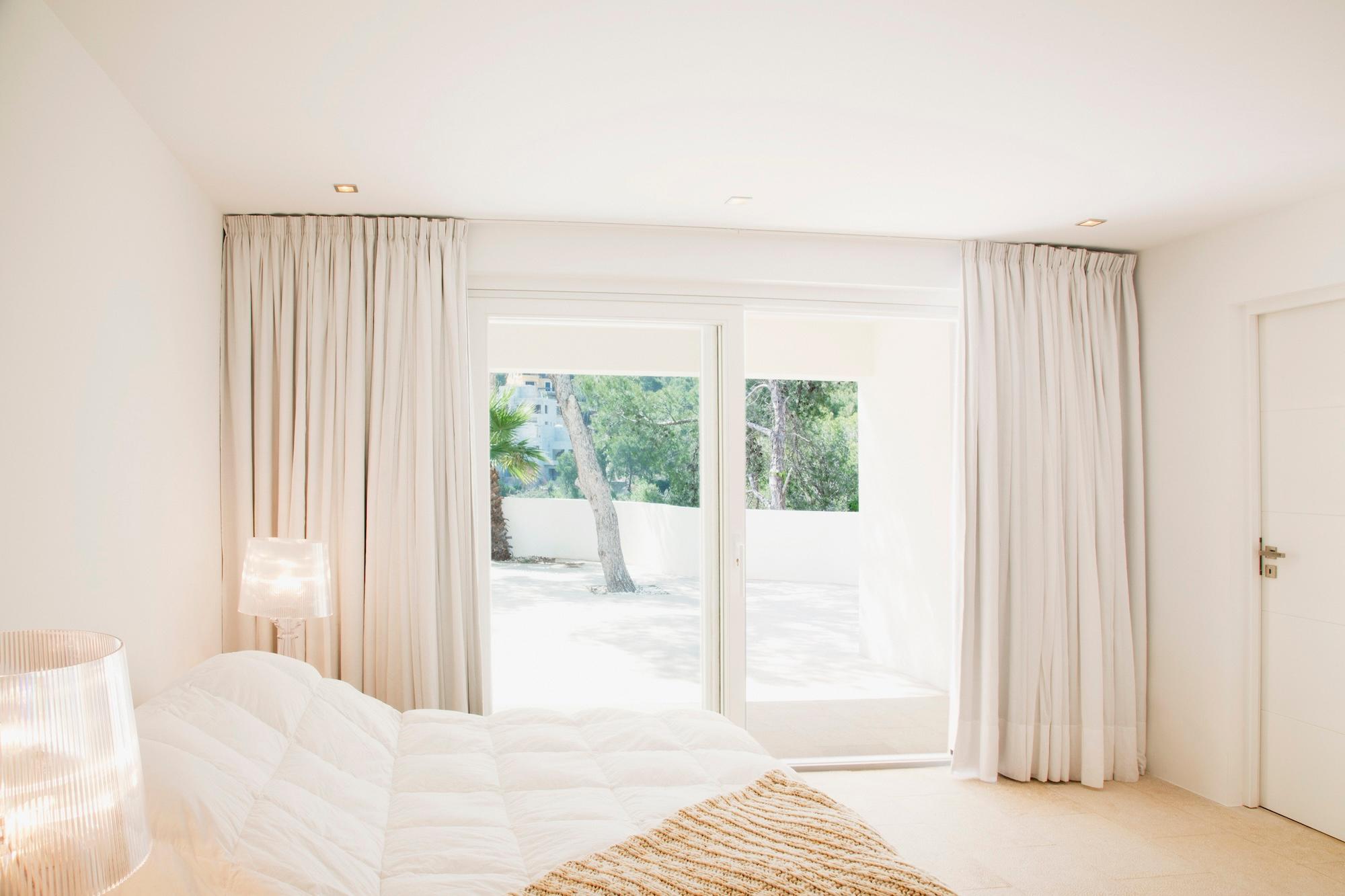 Curtains hanging in front of a sliding door in a bedroom