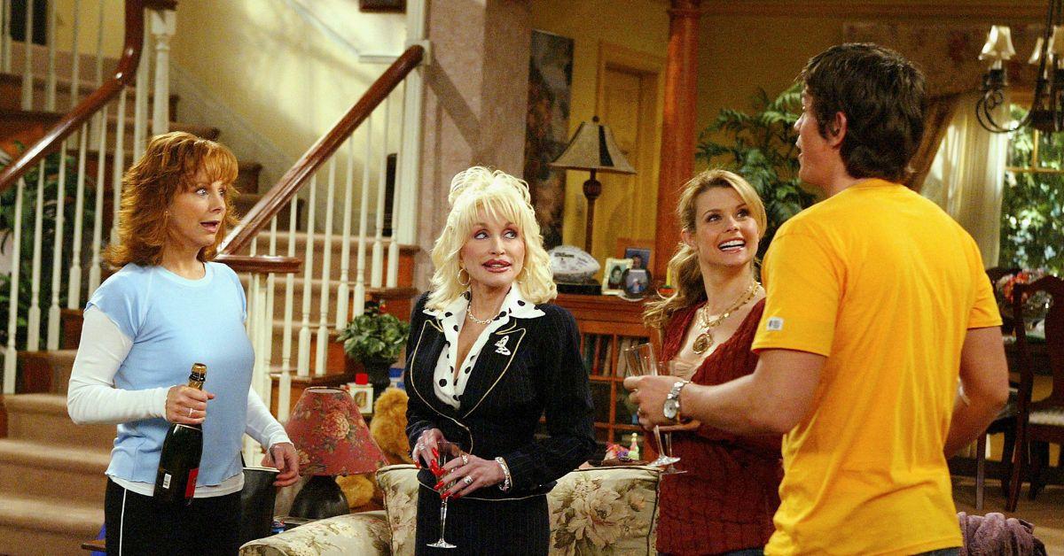 Reba McEntire, Dolly Parton, JoAnna Garcia Swisher, and Steve Howey talking during a scene of 'Reba.'