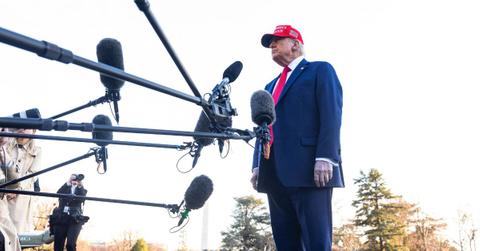 Donald Trump speaks in front of microphones on the White House lawn.