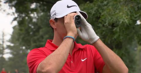 A golfer looking through a rangefinder.