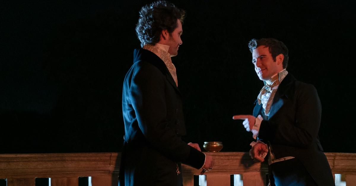 Benedict Bridgerton and Paul Suarez speaking on the balcony at Lady Tilly's house.