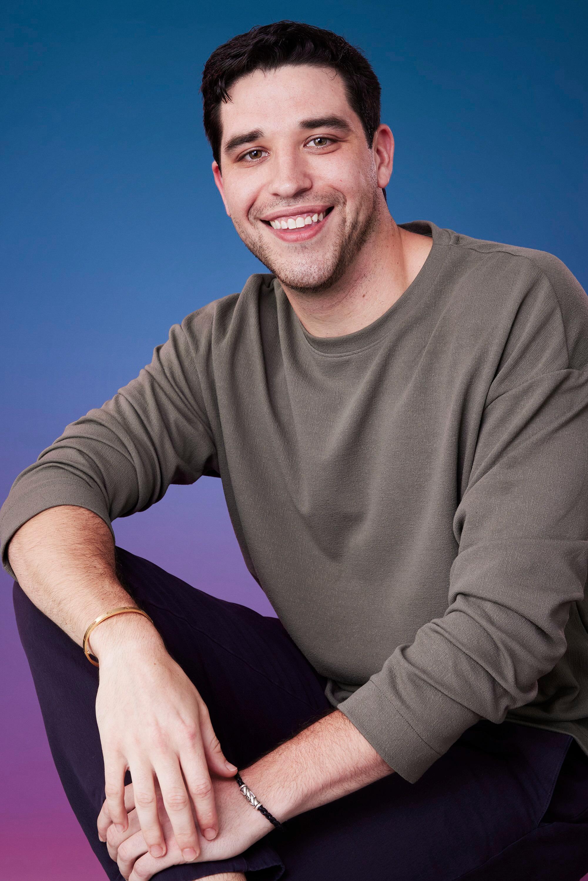 Devin poses in front of a blue-purple ombré background for his official 'The Bachelorette' Season 21 portrait.