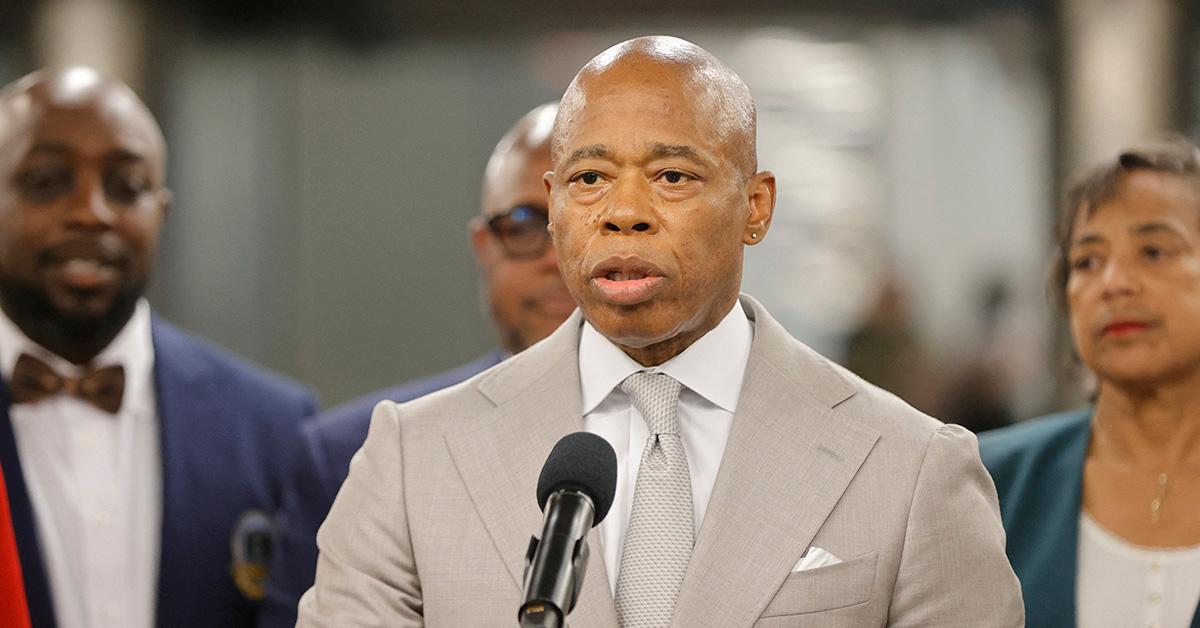 Eric Adams at a press conference in a gray suit. 