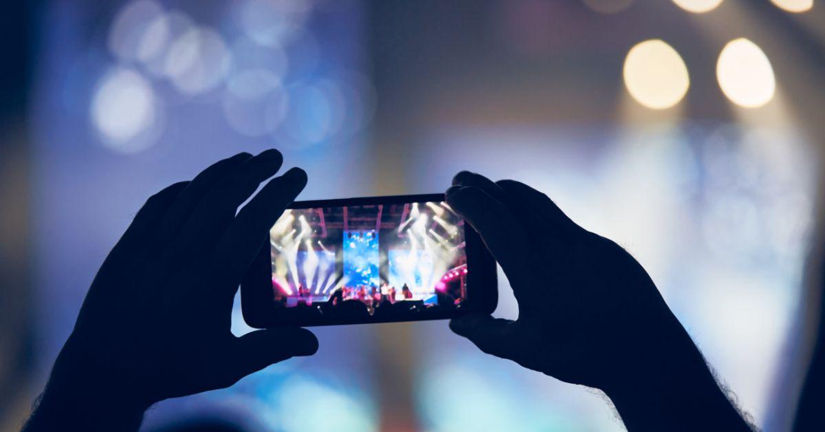 A person using a smartphone at a concert