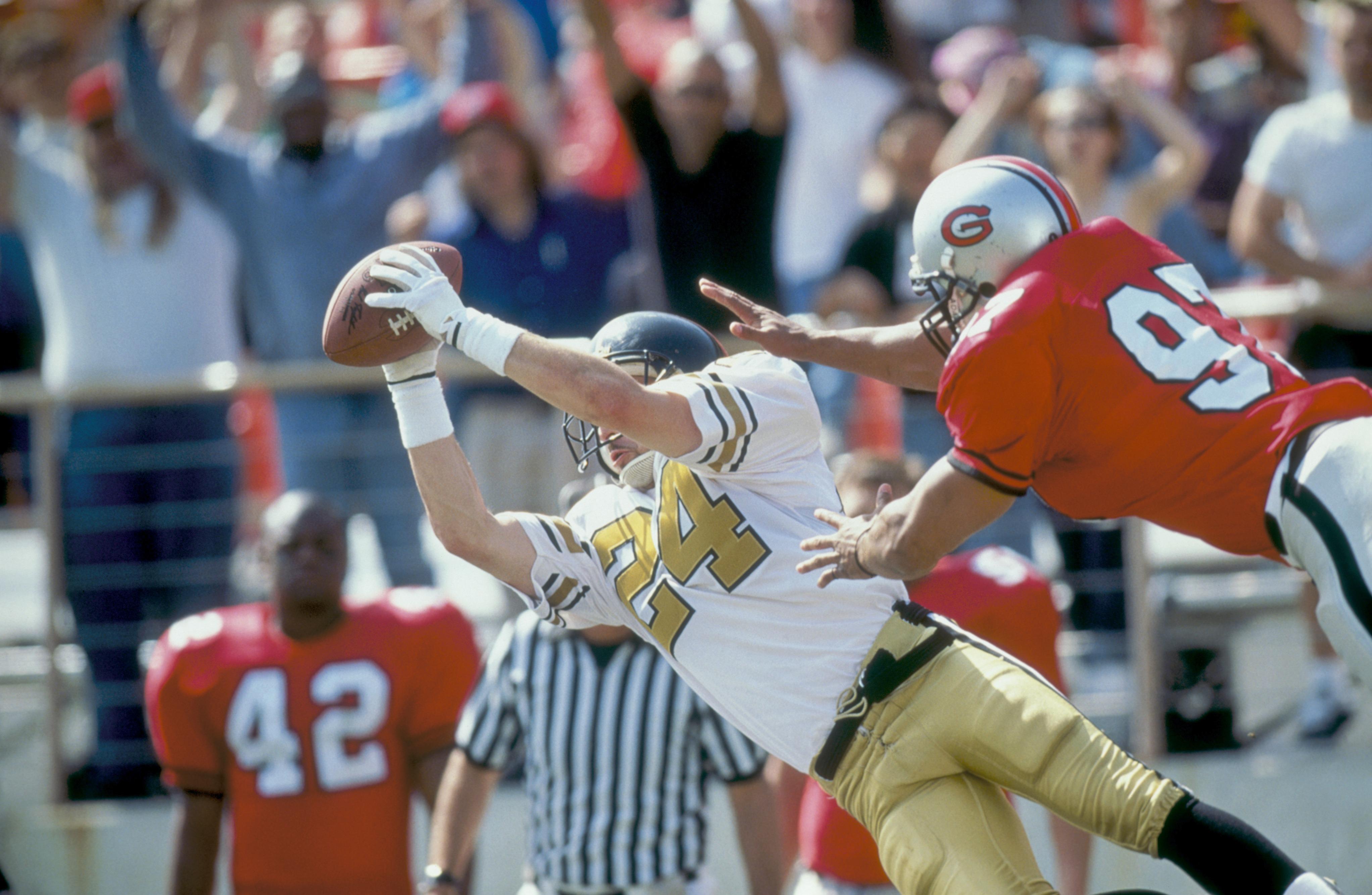 A football player catches the ball mid-air.