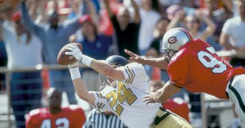 A football player catches the ball mid-air.