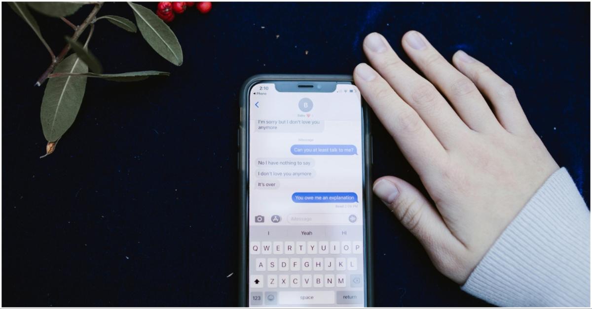 iPhone sitting on a table by a hand
