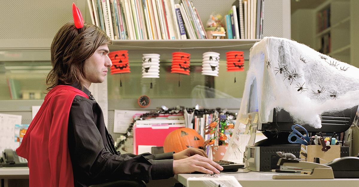 A man dressed as a vampire looking at Halloween costume memes.