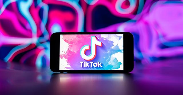 TikTok logo in white with a paint background.