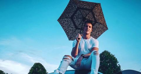 Sam taking a photo on top of one of his cars.