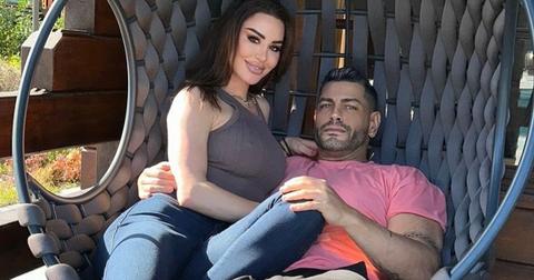 Shekinah and Sarper sit in a chair together outside