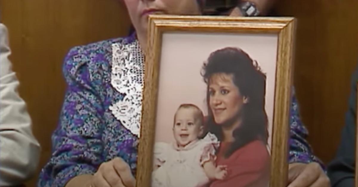 A family member holding up a photo of Farrah Fratta and one of her children