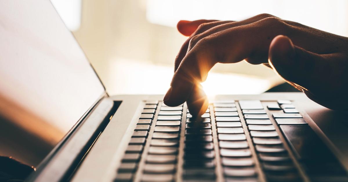 Person using a computer to write a novel.