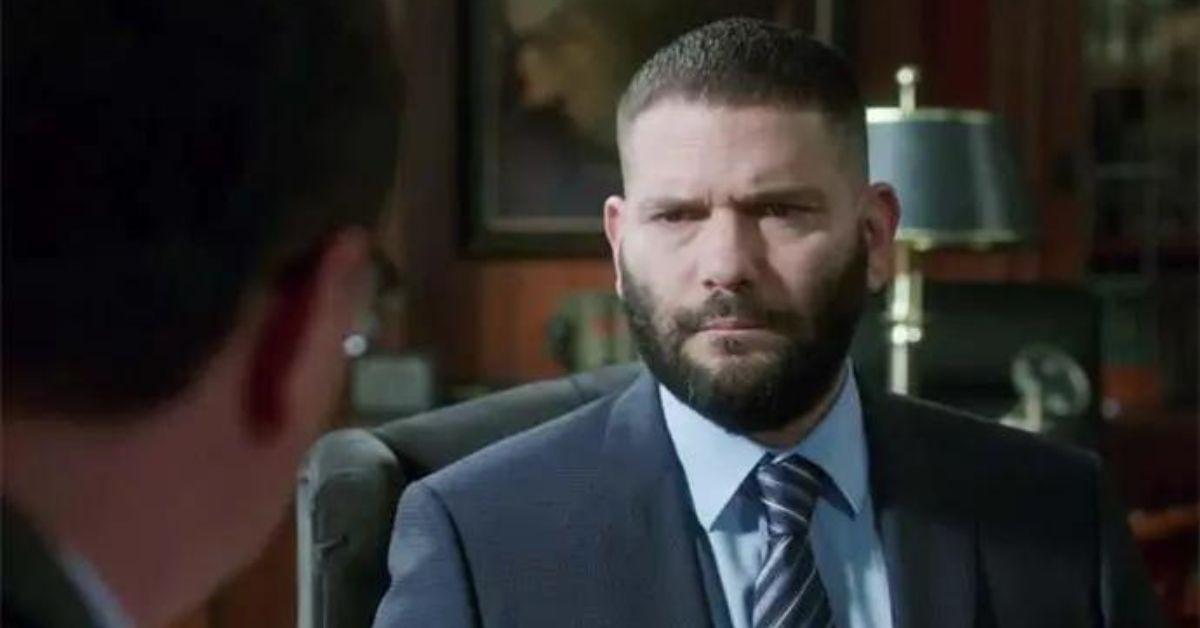 Huck from 'Scandal' sits in a boardroom wearing a suit