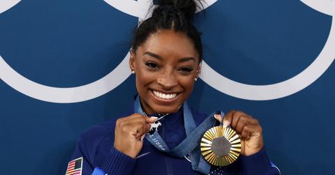 Gold medalist Simone Biles of Team United States poses with the Olympic Rings and a goat charm on her necklace during the Artistic Gymnastics Women's All-Around Final medal ceremony on day six of the Olympic Games Paris 2024 at Bercy Arena on August 01, 2024 in Paris, France. (Photo by Jamie Squire/Getty Images)