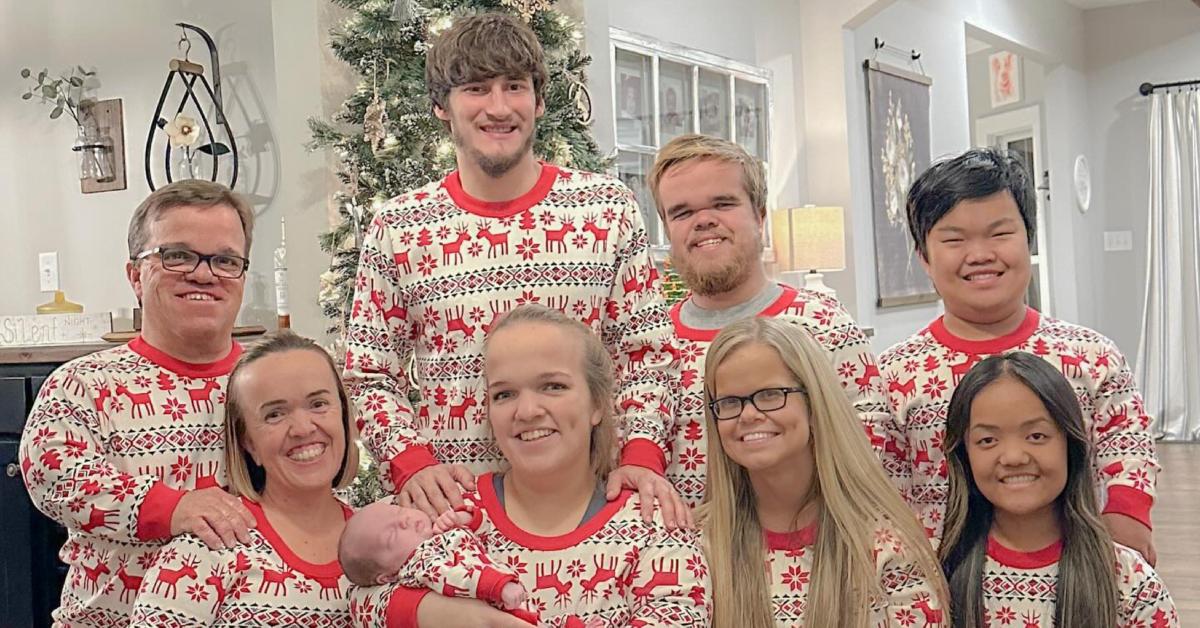 The Johnston family and Brice wear matching Christmas pajamas and pose in front of a Christmas tree.