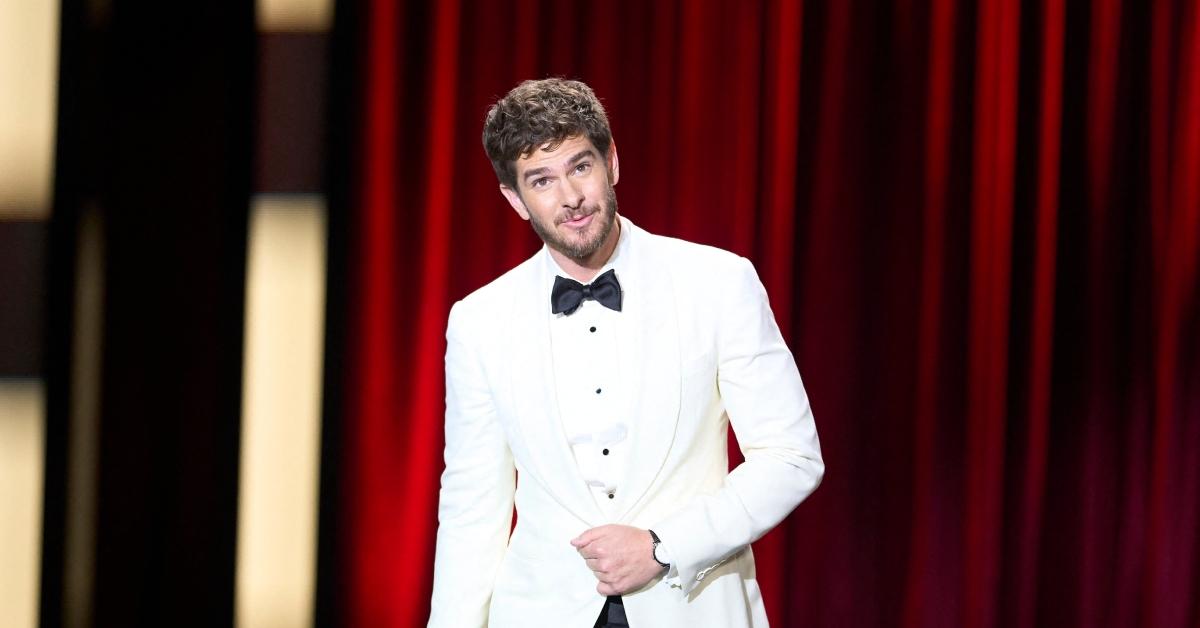 Andrew Garfield wearing a white suit on stage.