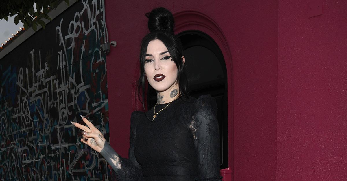 Kat Von D flashing a peace sign in a black, sheer dress. 