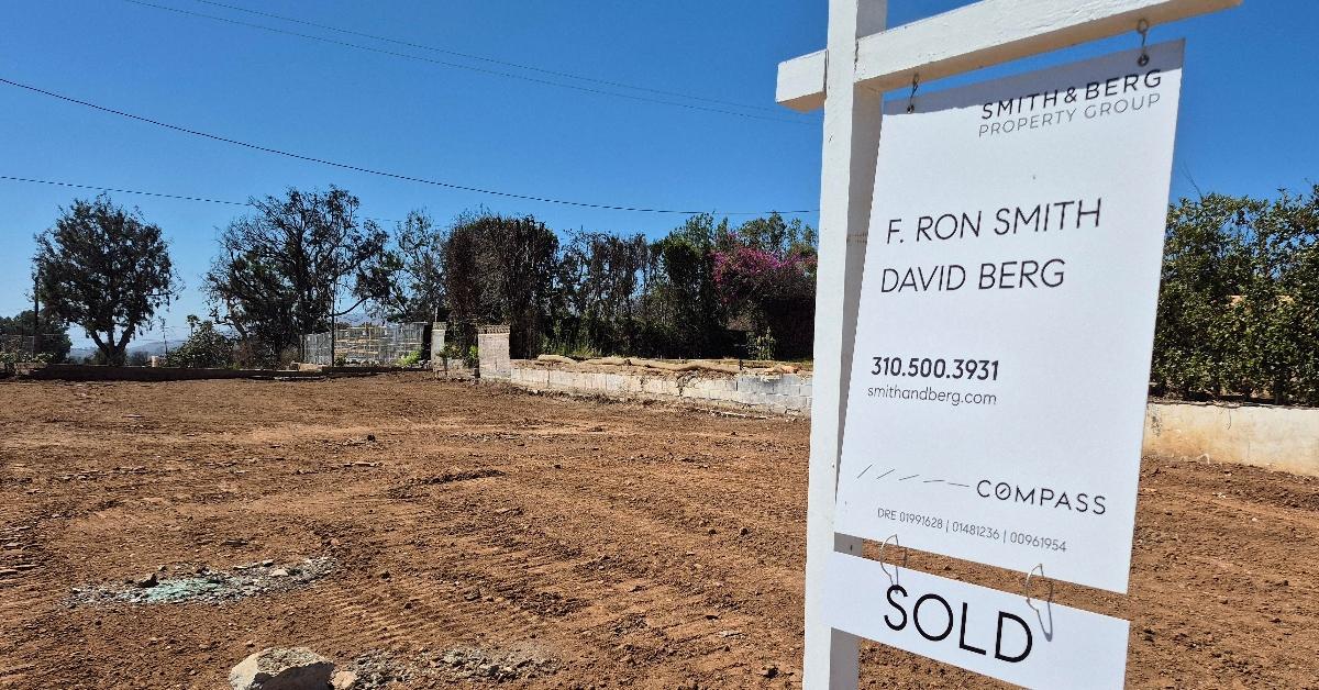 Real estate SOLD sign in front of an empty lot in the Pacific Palisades