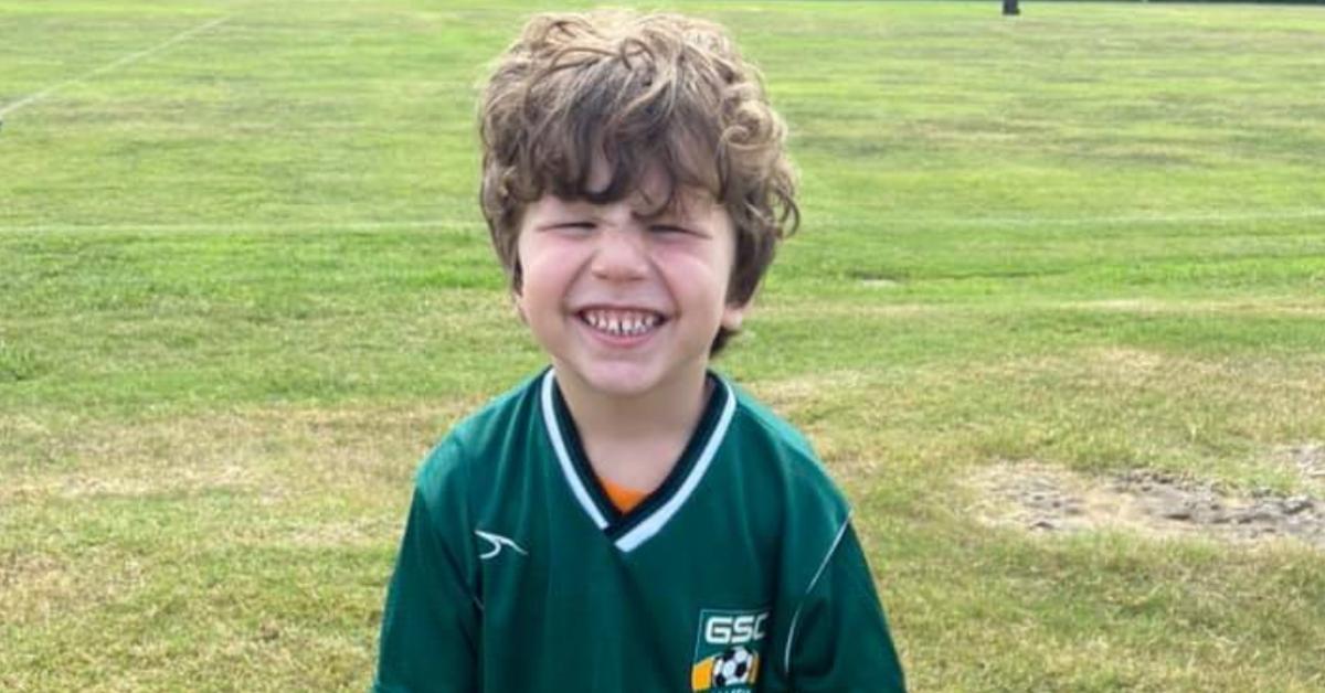 Noah Ennis smiles wearing a soccer uniform